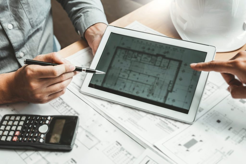 Contractor pointing at a tablet while creating a project estimate.